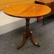 AN ANTIQUE OAK TILT-TOP TABLE of circular form, 76cms diam.