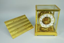 A JAGER LECOULTRE ATMOS CLOCK in a gilt brass and glass case having a white chapter ring with gilt
