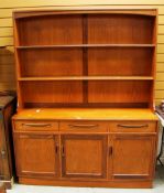 A G-PLAN OR G-PLAN STYLE TEAK DRESSER with three cupboard base, three drawers and an open rack