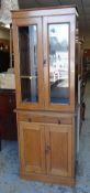 A GOOD VINTAGE OAK CUPBOARD BOOKCASE with two-door glazed upper single drawer and cupboard base,