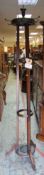 A VINTAGE CIRCULAR OAK TRIPOD COAT / UMBRELLA STAND with turned finial decoration and metal hooks,