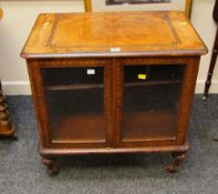 AN ANTIQUE WALNUT MUSIC CABINET composed of two glazed doors with marquetry decoration and on turned