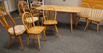 A MID TO LATE C20TH ERCOL BLONDE DINING TABLE AND CHAIR SET comprising rounded rectangular dining