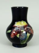 A WALTER MOORCROFT SQUAT BALUSTER VASE with Slipper Orchid design to a deep blue ground, 11cms high,