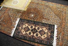 A PERSIAN CARPET with intricate floral medallion design 256 x 165cms together with two prayer mats