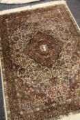 A PERSIAN FLORAL CARPET in dark colours with floral medallion design, 180 x 124cms