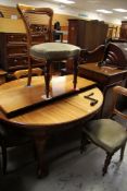 AN EXTENDING CIRCULAR / OVAL ANTIQUE DINING TABLE and four balloon back chairs (extra leaves and