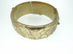 9CT YELLOW GOLD CLASP BANGLE with foliate engraving, 38gms