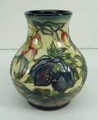 MOORCROFT POTTERY ONION SHAPED VASE decorated with tube lined flowers against a cream/mottled