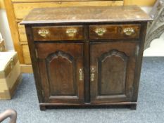 SMALL NINETEENTH CENTURY DRESSER BASE having panelled cupboard doors below two drawers on stile-