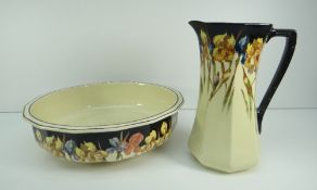 ROYAL DOULTON POTTERY TOILET JUG & BASIN of faceted form and decorated with tall flowers to a