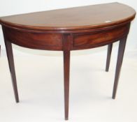 GEORGE III MAHOGANY HALF ROUND FOLD-OVER TOP TEA TABLE having a single drawer on tapered supports,