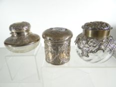 THREE SILVER / PART-SILVER DRESSING TABLE JARS one with cut-glass base and hinged lid, the second of