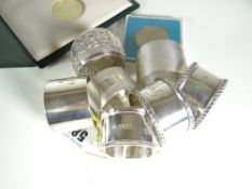 SIX ENGLISH HALLMARKED SILVER NAPKIN RINGS various designs together with an Indian silver similar,