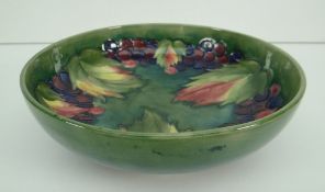 MOORCROFT POTTERY SHALLOW BOWL in the 'Leaf and Berry' pattern against a shaded green/blue ground,