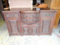 EARLY 20TH CENTURY BOW FRONT MAHOGANY SIDEBOARD with carved panel decoration