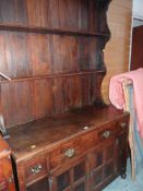 VINTAGE DRESSER having paneled two cupboard base, three drawers and open rack, 122cms wide