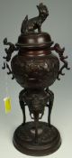 CHINESE BRONZE LIDDED CENSER raised over tripod supports on a circular base, 25cms high