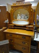 EARLY TWENTIETH CENTURY LIGHTWOOD DRESSING TABLE with three long drawers and folding flanking