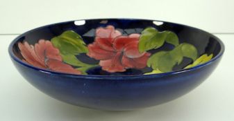MOORCROFT POTTERY SHALLOW BOWL in the Hibiscus pattern against a shaded blue ground, 26cms diameter