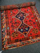 RED & BLUE GROUND PERSIAN RUG with triple centre decoration with animal and flower decoration,
