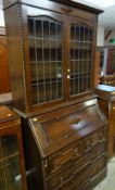 VINTAGE OAK BUREAU BOOKCASE with lead glazed upper doors, two short above two long drawers, 198cms