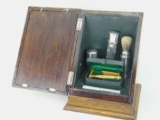 PART-SILVER SHAVING SET comprising silver mounted oak cabinet of sloped form with hinging cover