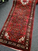 MAINLY RED GROUND WOOLLEN PERSIAN RUNNER with central decoration and patterned border, 306 x 84cms