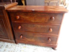 ANTIQUE FLAME-MAHOGANY COMPACT THREE-DRAWER CHEST OF DRAWERS on bun feet