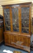 A REPRODUCTION LIGHT MAHOGANY CUPBOARD BOOKCASE, three astragal glazed upper doors above a three