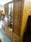 MODERN PINE EFFECT TRIPLE WARDROBE with centre mirror door and a nine-drawer base, 199cms high x
