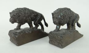 PAIR OF BRONZE BOOKENDS IN THE FORM OF LIONS on sloped naturalistic bases and in prowling pose,