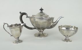 THREE-PIECE SILVER TEA SET of fluted form with castellated rim on stemmed supports, circular
