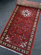 MAINLY RED GROUND PERSIAN WOOLLEN RUNNER with central decoration and narrow geometric patterned