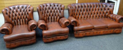 BROWN LEATHER THREE-PIECE SUITE comprising three seater sofa with studded back and two matching
