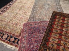 PARCEL OF FOUR PERSIAN WOOLEN RUGS the largest brown centre with floral pattern and blue border,