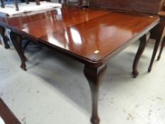 EARLY TWENTIETH CENTURY MAHOGANY EXTENDING DINING TABLE on cabriole legs with castors
