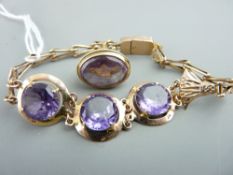 A 9CT GOLD & AMETHYST LINK BRACELET having three centre gold mounted amethysts with an oval amethyst