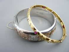 A WIDE HOLLOW HALF BRIGHT CUT SILVER BANGLE with believed rose gold decoration, 30gms, Birmingham