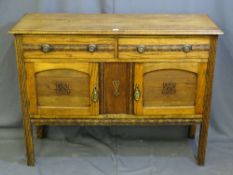 AN OAK TWO DRAWER OVER TWO BASE CUPBOARDS SIDEBOARD with carved detail and ringed pull handles