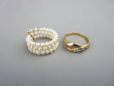 A YELLOW METAL & CZ DRESS RING, 3.1gms, size N/O and a pearl triple row 'sprung' ring, 3.3gms