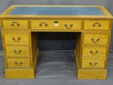 A MODERN LIGHT WOOD VENEERED TWIN PEDESTAL BLUE TOOL TOP DESK