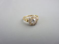 AN UNMARKED GOLD DIAMOND CLUSTER DRESS RING having a centre stone of visual estimate 1ct and with