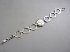 A CIRCULAR DIAL SILVER INTERMAT LADY'S WRIST WATCH with matching disc bracelet links, watch marked