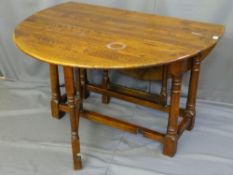AN OAK CIRCULAR TWIN FLAP GATE LEG DINING TABLE