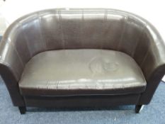 A TWO SEATER BROWN LEATHER EFFECT CURVED SETEE