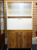 A CREAM AND WOOD EFFECT KITCHEN CABINET BY FORTRESS LTD, top shelves with sliding glass doors, a