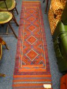 A MESHWANI RUNNER red and blue ground with central drop diamond block pattern, single continuous