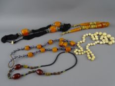 THREE AMBER TYPE NECKLACES and a graduated set of early 20th Century ivory beads
