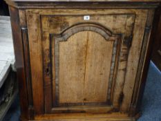 AN ANTIQUE OAK WALL HANGING CORNER CUPBOARD single door with cross banded panel detail and quarter